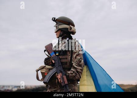 Ukrainische Kriegsverteidigerin. Porträt einer Militärfrau mit ukrainischer Flagge. Stockfoto