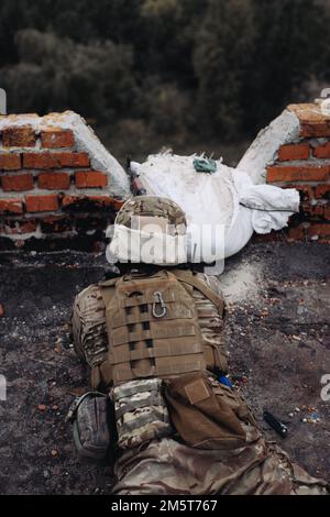 Das ukrainische Militär verteidigt seine Positionen. Soldat im Krieg, mit Waffen in der Hand, zielt auf den Feind Stockfoto