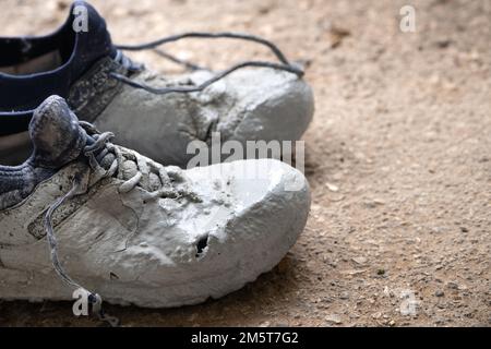 Schuhe stark mit grauer Farbe auf Asphalt verfärbt Stockfoto