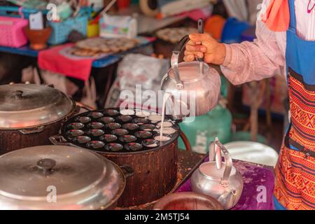 Zubereitung von Khanom Khrok oder Kokosnuss-Reis-Pfannkuchen, traditionelles thailändisches Dessert. Nationale Küche Thailands. Stockfoto