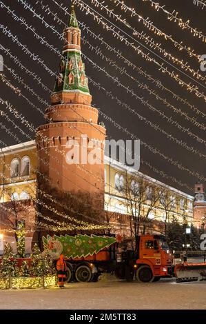 Moskau, Russland - 7. Dezember 2022: Das Auto KAMAZ räumt in einer kalten Winternacht Schnee von der Straße in der Nähe des Kremls und des Roten Platzes Stockfoto