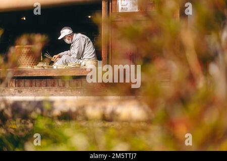 Ein alter Handwerker, der in einem ländlichen Dorf Kunsthandwerk bearbeitet Stockfoto