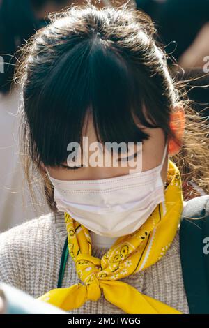 Ein kleines Schulmädchen trägt eine Maske in Asakusa Stockfoto