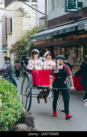 Rikscha-Arbeiter, der Touristen durch Asakusa fährt Stockfoto