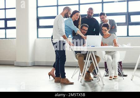 Alle Mann an Deck für ihr neuestes Projekt. Eine Gruppe von Kollegen, die eine Besprechung in einem Großraumbüro abhalten. Stockfoto