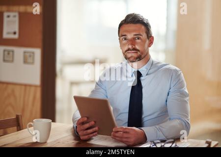 Er hat den digitalen Vorteil. Ein Geschäftsmann, der ein digitales Tablet verwendet. Stockfoto
