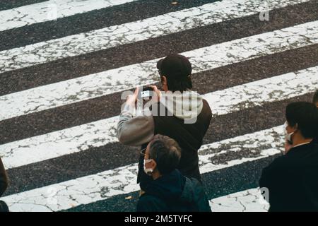 Leute, die Fotos von der berühmten Shibuya-Kreuzung machen Stockfoto