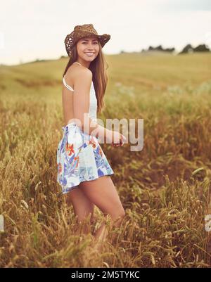 Nehmen Sie sich Zeit für die freie Natur. Eine junge Frau auf einem Weizenfeld. Stockfoto