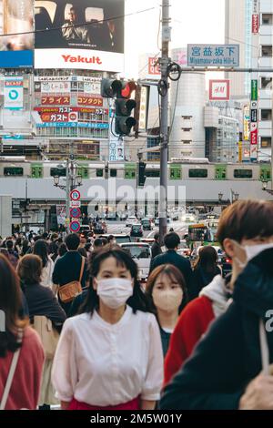 Menschenmassen mit Maske in den geschäftigen Straßen des Stadtzentrums von Shibuya Stockfoto