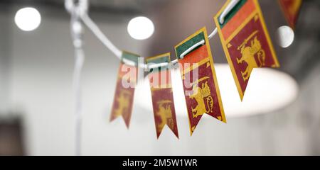 Eine Girlande Sri Lankas Nationalflaggen auf abstraktem, verschwommenem Hintergrund. Stockfoto