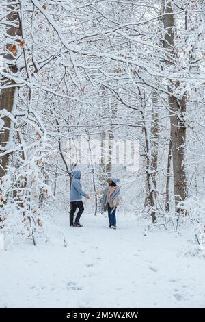 Ein Paar läuft durch den Winterwald. Stockfoto