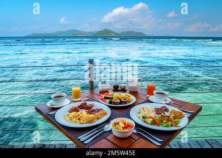 Frühstück am Strand am Pool mit Blick auf das Meer der La Digue Seychellen, tropische Insel Stockfoto