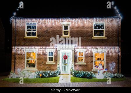 Wohnhäuser in Bicester, Oxfordshire, mit festlichen Weihnachtslichtern dekoriert. Stockfoto