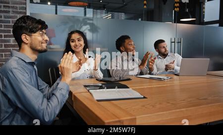 Zufriedene, multiethnische Mitarbeiter im Büro Hören Sie zu, wie Sie verschiedene Geschäftsleute Schulen, multinationales Team im Vorstand applaudieren und sich für den Seminarvortrag bedanken Stockfoto