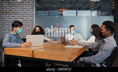 Vielfältiges Business Team Mitarbeiter in medizinischen Masken zusammenarbeiten im Büro multiethnische Kollegen multiethnische Gruppen Teamarbeit über Projekt diskutieren Stockfoto