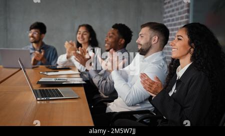 Zufriedene multiethnische Geschäftspartner Kollegen Mitarbeiter Mitarbeiter an Konferenzen Hören Sie Projektpräsentation Workshop Vorlesungen und klatschen Sie Hand in Hand Stockfoto