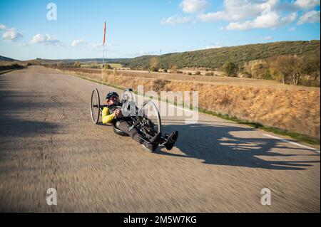 Sportler mit Behinderungstraining mit seinem Handbike auf der Rennstrecke. Hochwertige Fotografie. Stockfoto