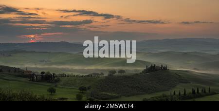 Hügelige Landschaft mit Anwesen Podere Belvedere bei Sonnenaufgang, Val dOrcia, San Quirico dOrcia, Provinz Siena, Toskana, Italien Stockfoto