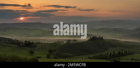 Hügelige Landschaft mit Anwesen Podere Belvedere bei Sonnenaufgang, Val dOrcia, San Quirico dOrcia, Provinz Siena, Toskana, Italien Stockfoto