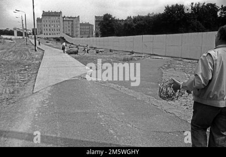 DDR, Berlin, 13. Juni 1990, Abriss der Mauer in der Bernauer Straße, reich an Geschichte, Abriss durch NVA-Einheiten, Mann mit Stacheldraht, C Rolf Stockfoto