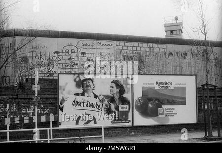 DDR, Berlin, 04. 02. 1990, Werbetafel an der Liesenstraße, im Hintergrund ein Wachturm, Rolf Zoellner C. Stockfoto