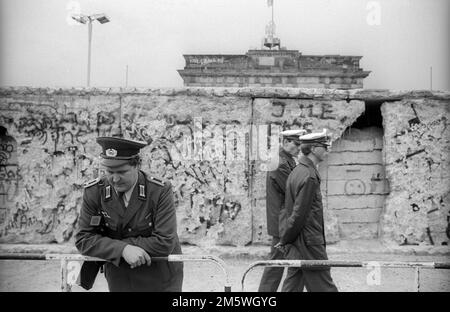 DDR, Berlin, 10. 03. 1990, Volkspolizist und Westberliner Polizei, Mauer am Brandenburger Tor Stockfoto