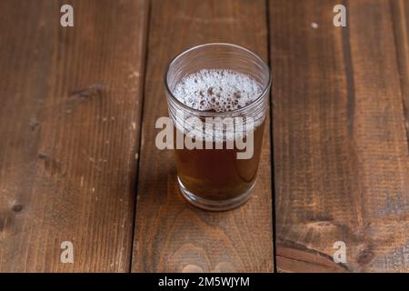 Glas Tee mit Schaum auf einem rustikalen Holztisch. Erfrischung, Pause, Getränk. Stockfoto