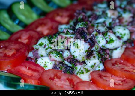 Köstlicher frischer Salat mit Meeresfrüchten. Gemischt mit Tomaten, Kräutern, Olivenöl. Gesunde mediterrane Vorspeise. Stockfoto