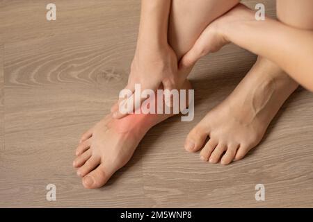 Schmerzen in den Beinen. Frauenfüße auf dem Boden. Orthopädische Erkrankungen Gelenke, Muskeln. Gesundheitsproblem Stockfoto