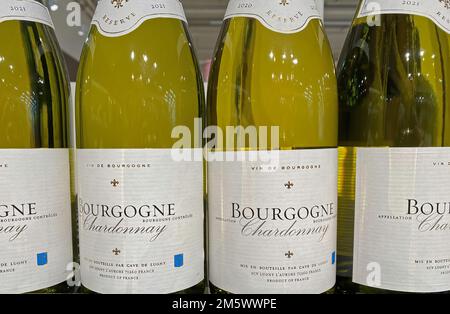 Viersen, Deutschland - 9. Dezember. 2022: Vervollständigung von Flaschen französischen Bourgogne chardonnay Weißweins im Regal des deutschen Supermarkts Stockfoto