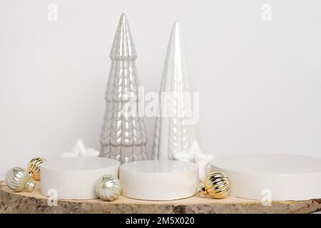 Podium zur Präsentation auf Holzständer mit Weihnachtsbaumschmuck auf weißem Hintergrund. Moderne Geometrische Form. Zylinderkugel. Szene zu Sh Stockfoto