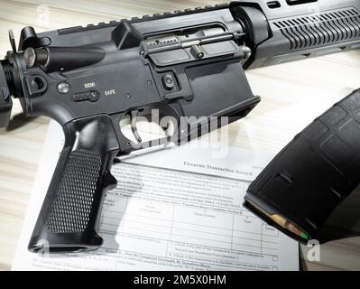 AR-15 mit Magazin mit hoher Kapazität und öffentlich zugänglichem NICS-Formular zur Hintergrundüberprüfung Stockfoto