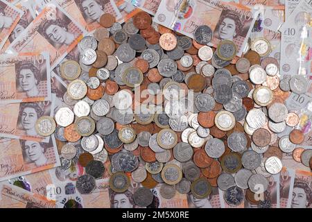 £10 Banknoten und ein Stapel britischer Münzen, einschließlich der Stückelungen of1p, 2p, 5p, 10p, 20p, 50p sowie £1 und £2 Münzen Stockfoto