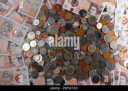 £10 Banknoten und ein Stapel britischer Münzen, einschließlich der Stückelungen of1p, 2p, 5p, 10p, 20p, 50p sowie £1 und £2 Münzen Stockfoto