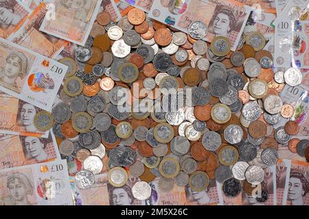 £10 Banknoten und ein Stapel britischer Münzen, einschließlich der Stückelungen of1p, 2p, 5p, 10p, 20p, 50p sowie £1 und £2 Münzen Stockfoto