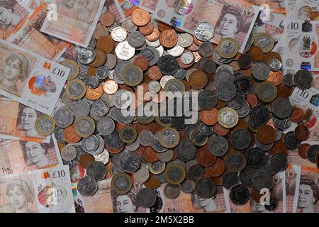 £10 Banknoten und ein Stapel britischer Münzen, einschließlich der Stückelungen of1p, 2p, 5p, 10p, 20p, 50p sowie £1 und £2 Münzen Stockfoto