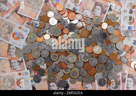 £10 Banknoten und ein Stapel britischer Münzen, einschließlich der Stückelungen of1p, 2p, 5p, 10p, 20p, 50p sowie £1 und £2 Münzen Stockfoto