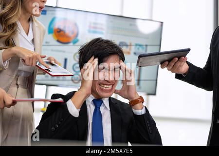 Gestresster, überforderter Geschäftsmann fühlt sich bei der Arbeit müde Überlastung erschöpft unter Kopfschmerzen Stockfoto
