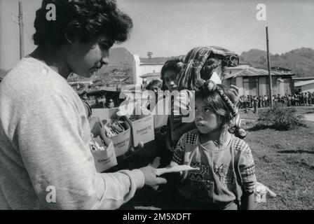 Guatemala, April 1986; der Vertrieb von Weizen, Milch und Öl durch die US-amerikanische Behörde CARE findet alle zwei Wochen in Chajul, Provinz Quiche, statt. Die Lebensmittel sind alle Teil des PL 480-Programms der US-Regierung. Stockfoto