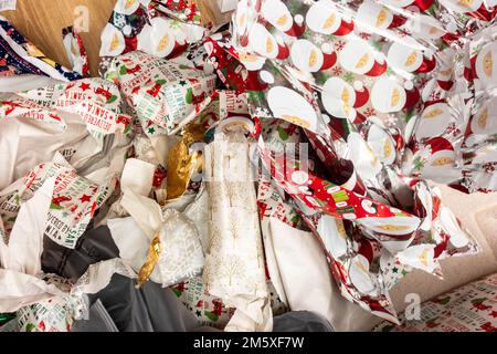 Stapel von weggeworfenen Weihnachten Geschenkpapier links auf dem Boden nach präsentiert geöffnet worden sind. Stockfoto