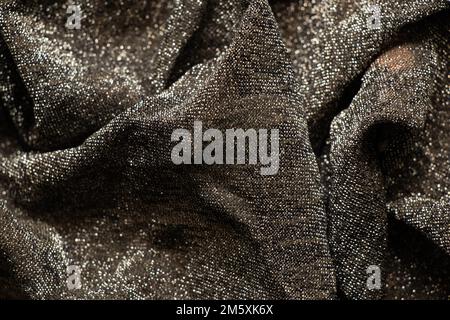 Schwarz glänzender zerknitterter Schal als Hintergrund-Nahaufnahme Stockfoto