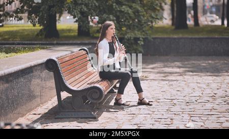 Ein Mädchen spielt Klarinette im Park. Stockfoto