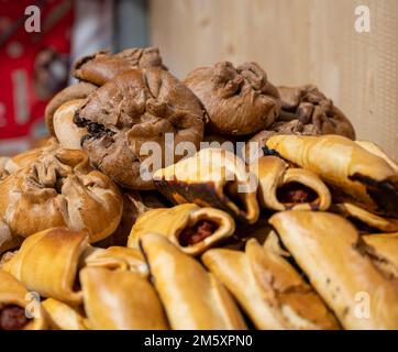 Spanische Snacks und Street Food, gebackener Kuchen Empanadilla mit verschiedenen Füllungen auf dem Markt in San-Sebastian, Spanien, aus nächster Nähe Stockfoto