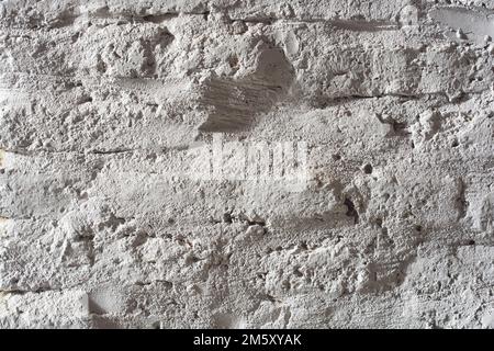 Horizontale Nahaufnahme des weißen Ziegelhintergrunds mit Details der grunge-gealterten Textur. Stockfoto