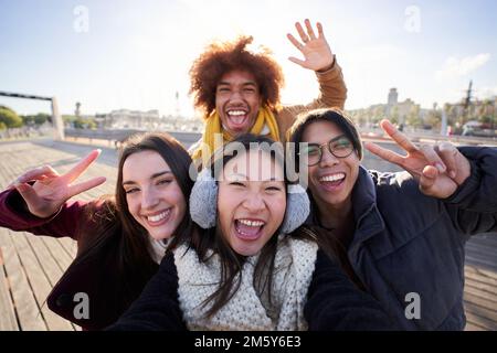 Selfie einer Gruppe glücklicher Menschen, die Selfie-Fotos mit einem Telefon in Winterkleidung machen. Stockfoto