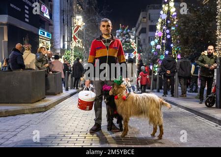 Istanbul, Türkei. 31. Dezember 2022: Ein Mann, der seine Ziegen auf der Straße führt, posiert. Die Bürger von Nisantasi begrüßten das neue Jahr in der Abdi Ipekci Straße, die am 31. Dezember 2022 in Sisli, Istanbul, Turkiye, mit Lichtern geschmückt wurde. Bürger und Touristen, die das neue Jahr an wichtigen Punkten der Stadt begrüßen wollten, versammelten sich auf den Plätzen und Straßen. (Kreditbild: © Tolga Ildun/ZUMA Press Wire) Kredit: ZUMA Press, Inc./Alamy Live News Stockfoto