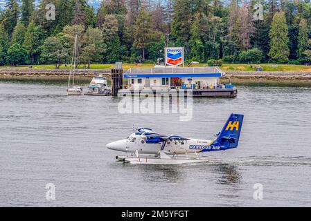 Vancouver, BC - 17. Juli 2022: Ein Twin Otter de Havilland Harbour Air Wasserflugzeug mit dem schwimmenden Treibstoffkahn Chevron im Coal Harbour in Vancouver, Britis Stockfoto