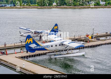 Vancouver, BC - 17. Juli 2022: Zwei Single Otter de Havilland Harbour Air Wasserflugzeuge, die im Coal Harbour in Vancouver, British Columbia, Kanada, anlegen Stockfoto