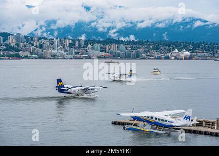 Vancouver, BC - 17. Juli 2022: Boote und Hafenflugzeuge im Coal Harbour mit der Skyline von North Vancouver, BC im Hintergrund Stockfoto