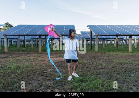 Solarfarm auf grünem Baum im Dorf bietet saubere Energie, umweltfreundliche kinderfreundliche Spieldrachen Stockfoto